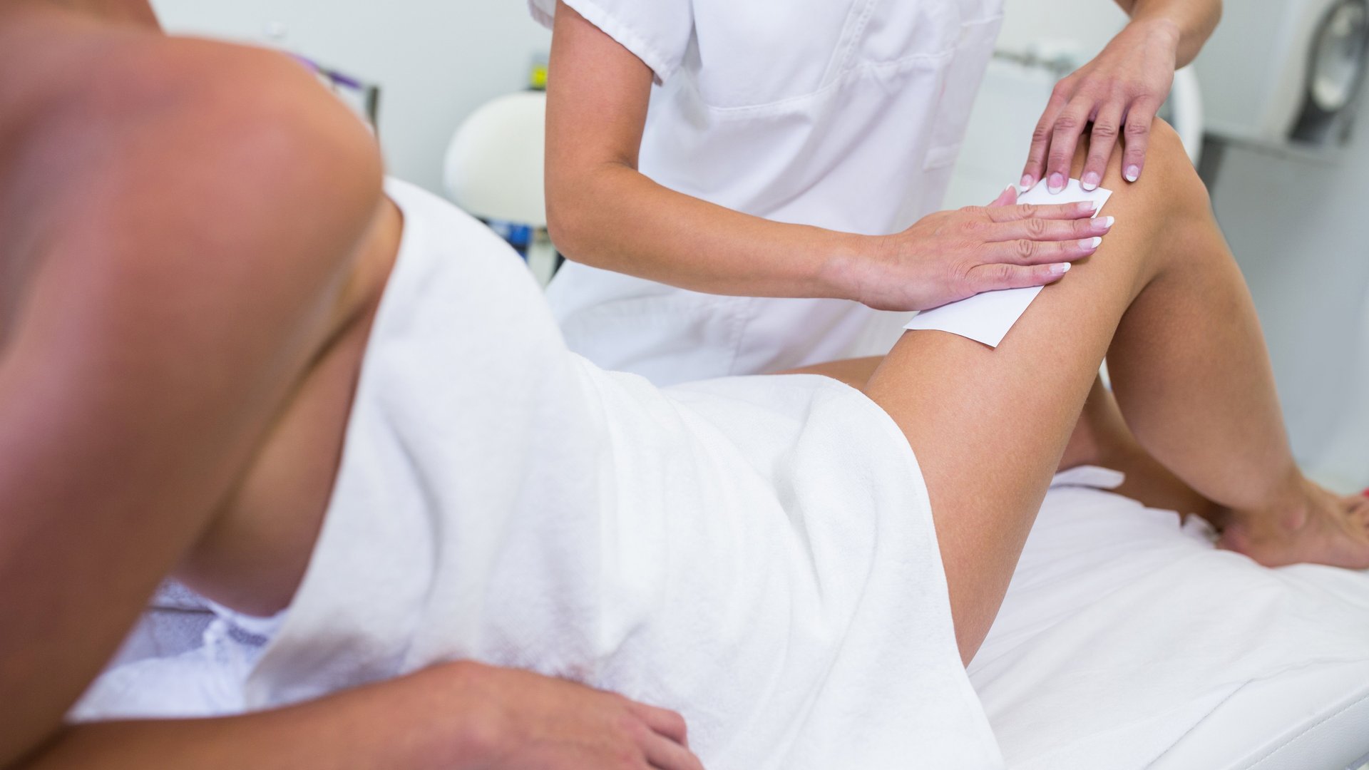 woman getting her leg hair removed at beauty salon